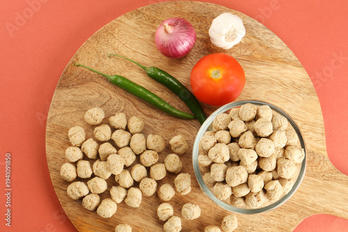Raw soya chunks ,garlic ,green chilli, onion, tomato, on cutting board . Healthy, nutritious soybean meat, chunks Vegan food concept.  known as soya wadi or meal maker in India