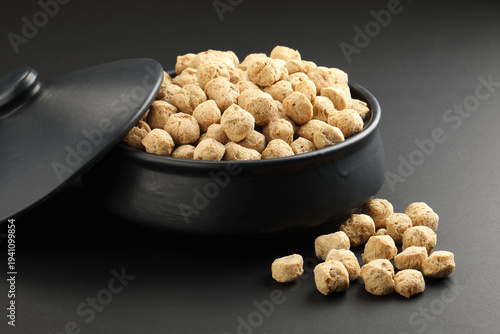 Raw soya chunks on  background. Healthy, nutritious soybean meat, chunks Vegan food concept.  known as soya wadi or meal maker in India 