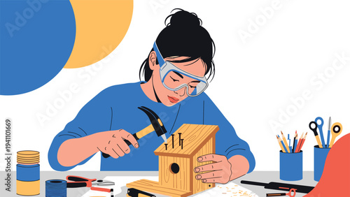 Young woman wearing protective eyewear uses a hammer to assemble a wooden birdhouse at a desk filled with craft tools.