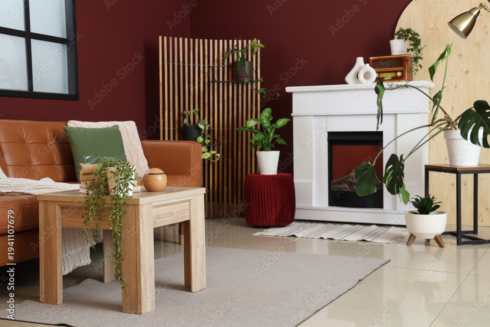 Naklejka premium Interior of stylish living room with cozy brown sofa, wooden coffee table and fireplace