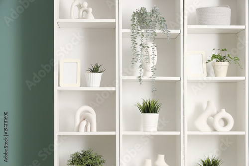 White shelf unit with plant...