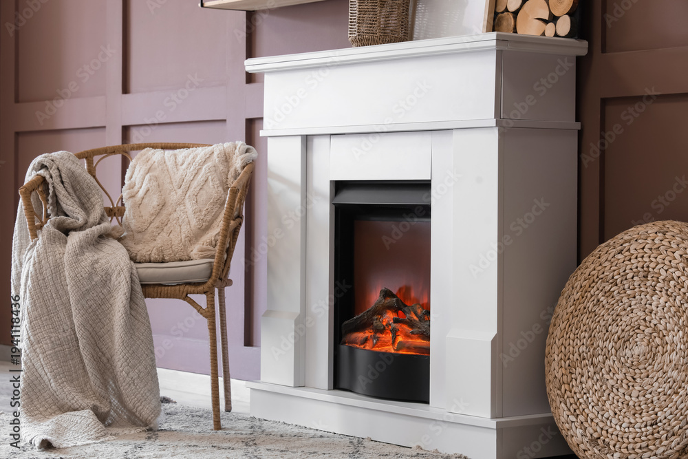 Fototapeta premium Fireplace with armchair and decor near brown wall in living room