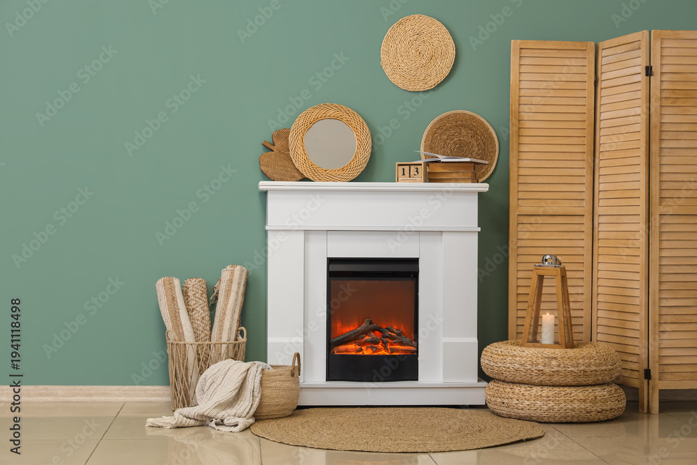 Obraz premium Fireplace with folding screen and decor near turquoise wall in living room