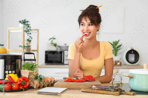 Young woman eating bell pep...
