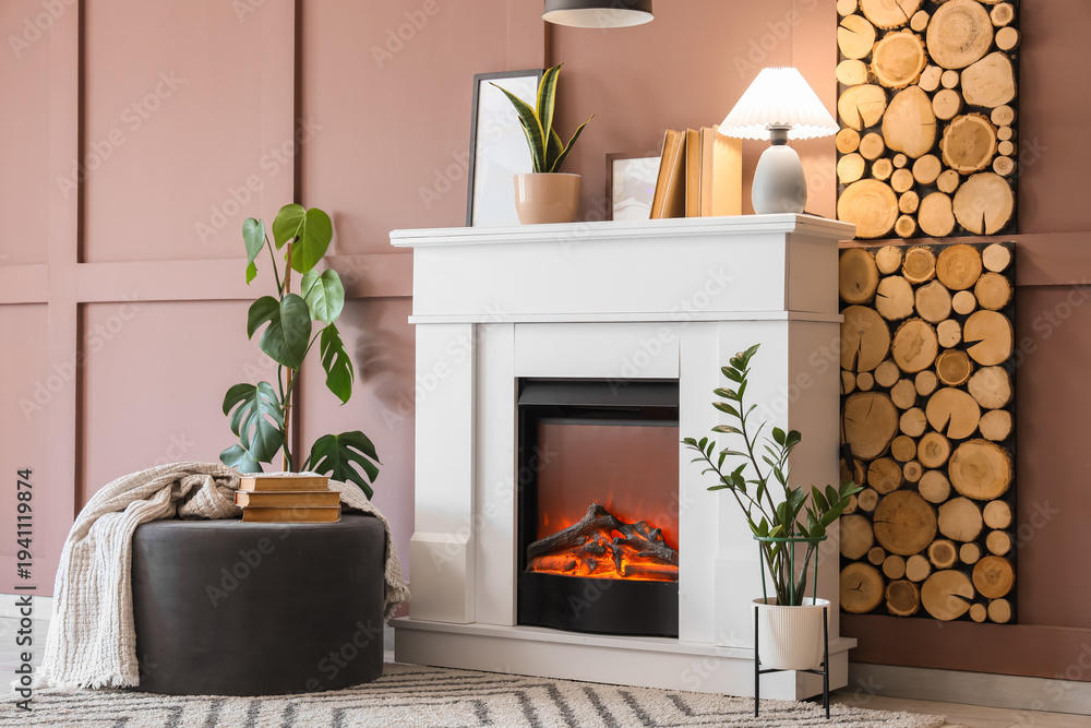 Fototapeta premium Interior of cozy room with glowing lamp, pouf and stylish fireplace
