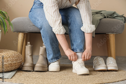 Young woman putting on snea...
