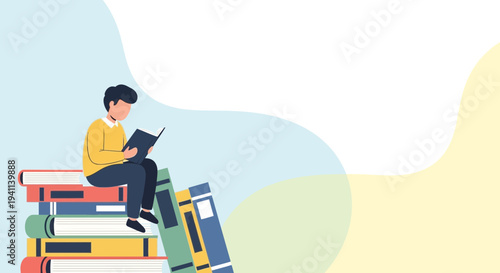 Young man reading a book while sitting on a stack of books.