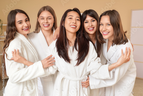 Group of young women hugging at Hen Party in bedroom