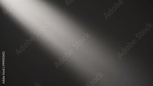 Floating dust particles suspended in a diagonal beam of light against a dark background. Atmospheric sunbeam shining through darkness with drifting specks. Cinematic overlay concept with copy space