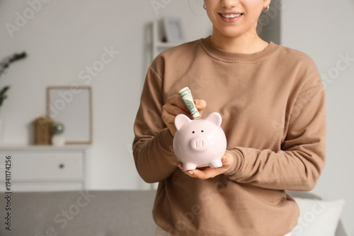 Young woman putting money i...