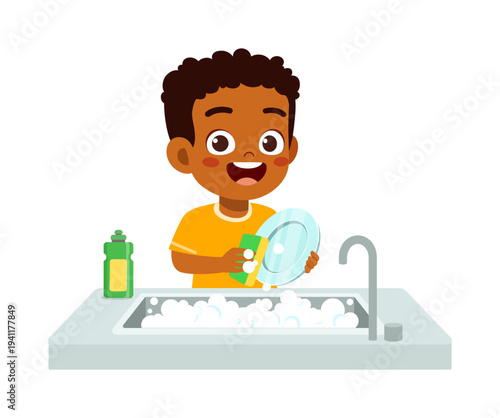 Happy African American boy smiling while washing dishes with a sponge and soap in a kitchen sink