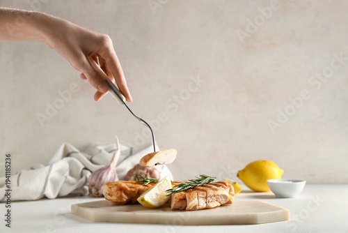 Woman eating grilled chicke...