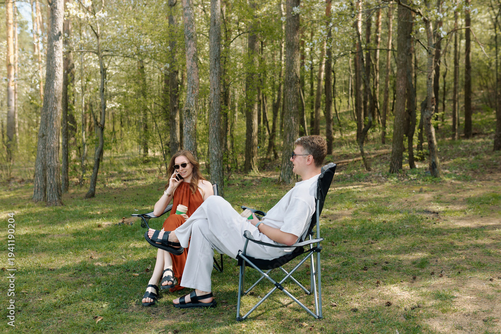 Fototapeta premium Young friends relax outdoors in a forested area during a sunny day in spring