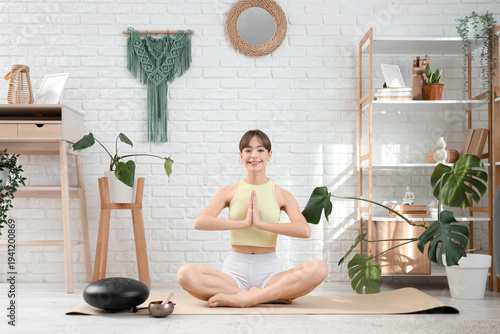 Young woman meditating on y...