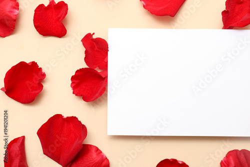 Blank card with beautiful red rose petals on beige background