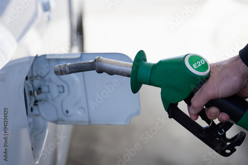 Fotografía man refilling car with e20 biofuel at gas station, hand holding green fuel nozzl