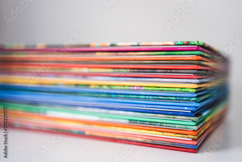 pile of colorful children books on white desk with shallow depth of field