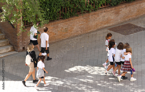 Niños pequeños de colegio infantil vuelta al cole escolar camino a clase a estudiar tras recreo en la calle