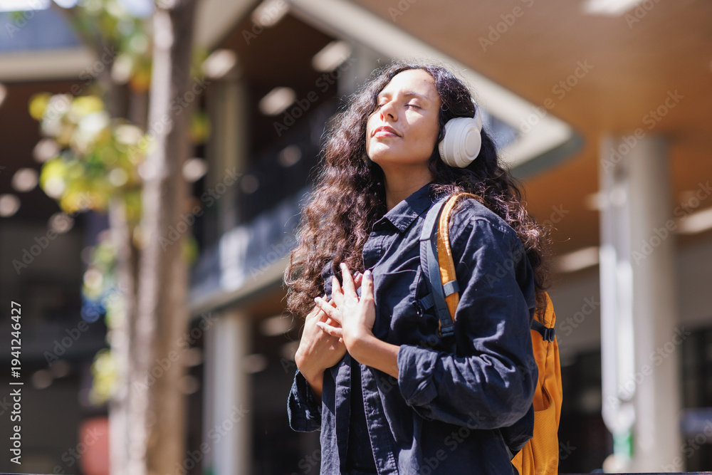 Fototapeta premium Woman enjoying music and finding peace outdoors