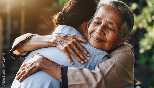 Two elderly women embracing warmly outdoors, showing affection and companionship.