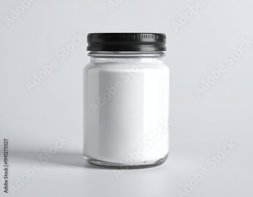 Clear glass jar filled with white powder, black lid