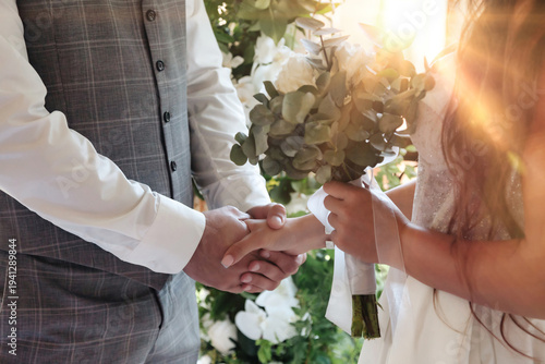 Obraz na plátně A Bride in a white dress is holding a bouquet