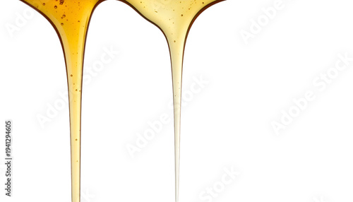 Close-up of two parallel golden liquids dripping against a black background