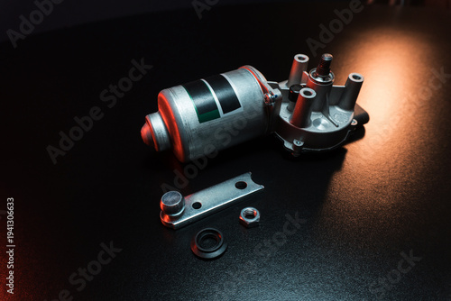 new electric motor for car wipers for windshield cleaning, repair at the service, shooting in a dark room, red light illumination