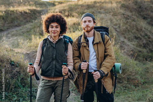 Fotografie Portrait of young mixed race family with Nordic walking poles at sunset countrys
