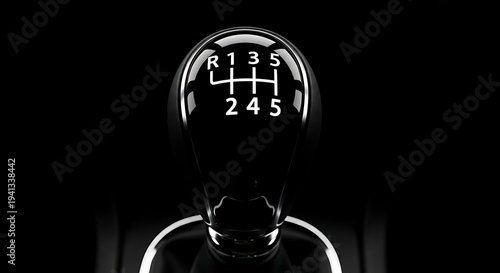Close-up of a glossy black gear stick shift knob in a car, manual transmission