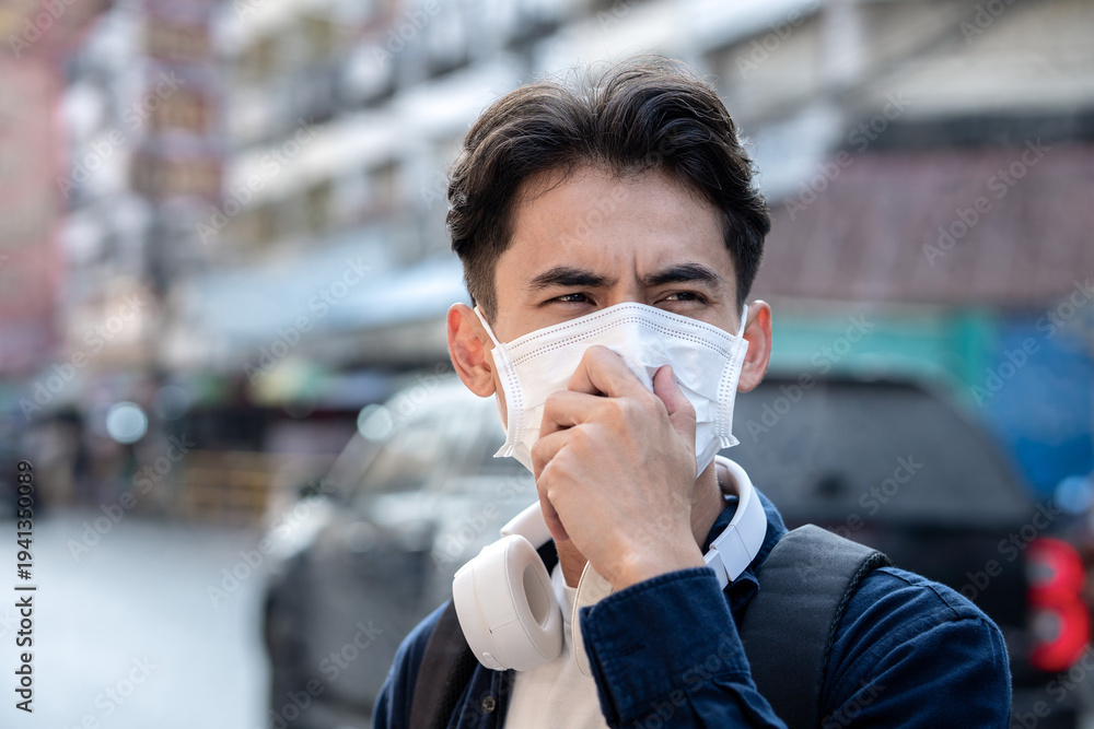 Obraz premium Air pollution quality of dust PM 2.5 is toxic and dangerous to health. Man having a sore throat wearing Protection mask unhealthy air pollution dust smoke in an urban city and smog with bad weather.