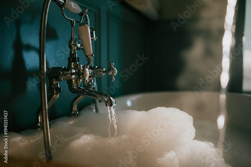 Картината върху платно Vintage bathtub fills with soapy water, steam rising gently