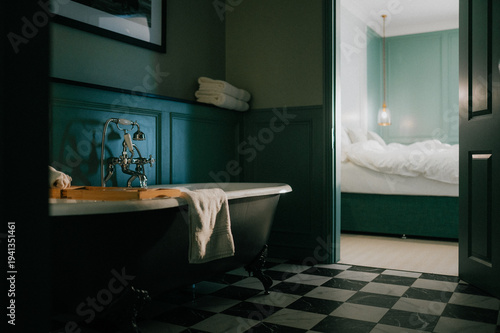 Εκτύπωση καμβά Dark, moody bathroom with vintage tub and checkered floor