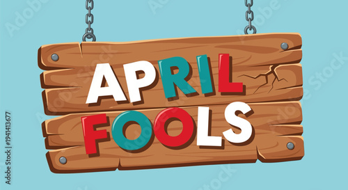 Colorful wooden sign with 'april fools' text hanging on chains against light blue background