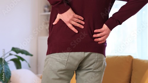 Man with hip, back, spine and sciatica pain at home.	
