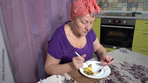 Senior alone elderly woman eating. Eat food and talk. Kitchen table at home.