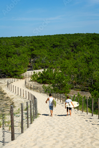Péninsule du Cap-Ferret, Bassin d'Arcachon, France, Gironde, Nouvelle-Aquitaine, jeunes surfeurs sur un chemin d'accès lunaire