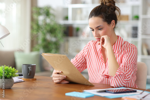 Freelance worker reading form or contract at home