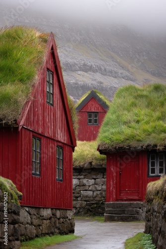 In a quaint village nestled in the Faroe Islands, striking red houses with lush green grass roofs emerge from the thick fog on a brisk morning