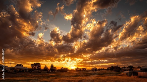 Golden sunset sky filled with glowing clouds and warm light creating dramatic atmospheric landscape