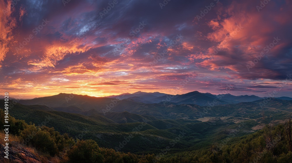 Fototapeta premium Panoramic mountain range stretching across horizon with dramatic sunset sky
