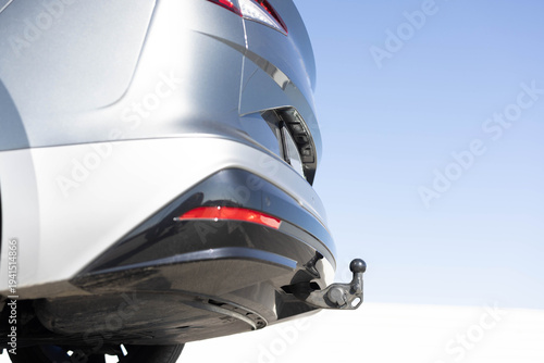 Towbar on a car, black steel part. Tow bar and tow ball on a car. Car detail. Foldable tow device switch