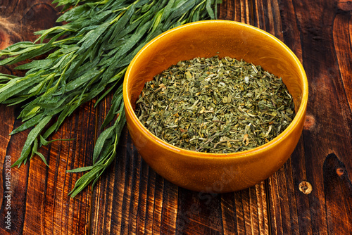 Bild auf Leinwand Green tarragon herb with dried leaves in bowl