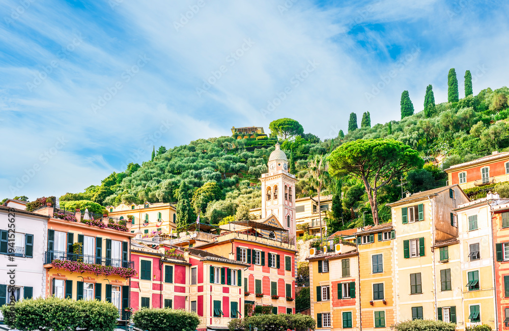 Fototapeta premium beautiful landscape of famous italiat resort Portofino in Luguria with ancient houses and buildings of hotels and restaulants along the embarkment of a sea gulf with sunset golden light