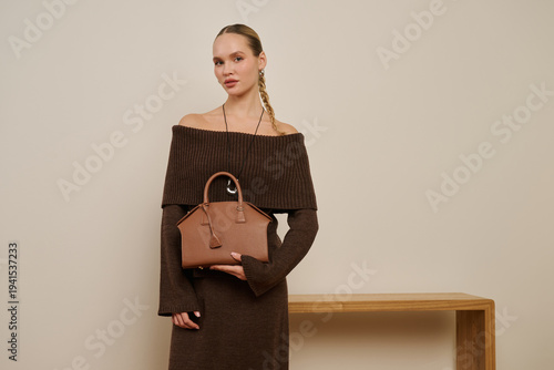 Stylish woman in brown outfit posing indoors