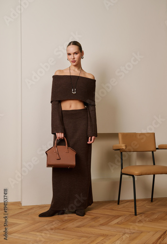 Stylish woman in brown outfit posing indoors