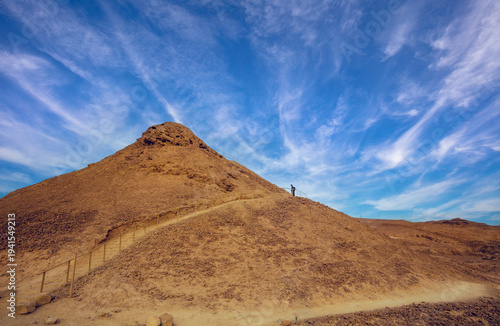 A man hiker climbs up a mountain stairs