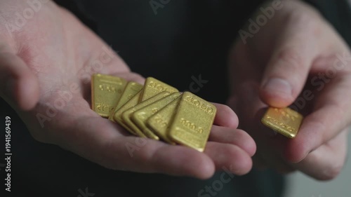  Close-Up of Man Holding Gold Bars in Hand