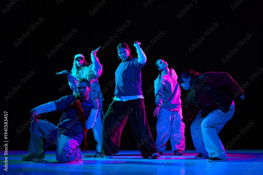 Naklejka premium Hip hop dance performance with neon lighting and crew choreography for music branding, nightlife promotion, entertainment advertising and youth culture marketing campaigns