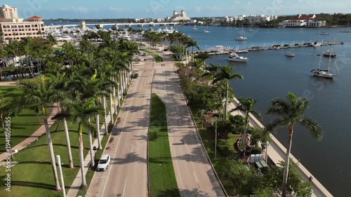 Cinematic Aerial View Perspective of West Palm Beach Waterfront Promenade Flanked by Royal Palms and Luxury Yachts